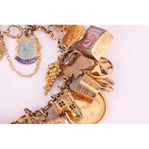 52 - A charm bracelet in 9ct gold, with a variety of charms including two half sovereigns; Edward VII, 19... 