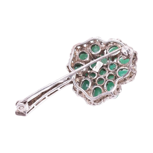 59 - An emerald-set shamrock brooch, the oval mixed-cut emeralds centrally set in a trefoil pattern, surr... 