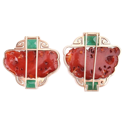 72 - Two Chinoiserie carved amber and emerald clip brooches; both similarly designed and centred with a C... 