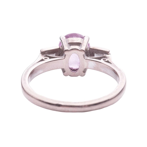 79 - A pink sapphire and diamond dress ring, centred with an oval-cut pink sapphire approximately measure... 