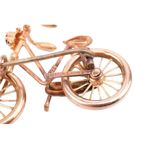 88 - A bicycle brooch with a pink paste accent, with spinnable wheels and brooch fittings to the reverse,... 