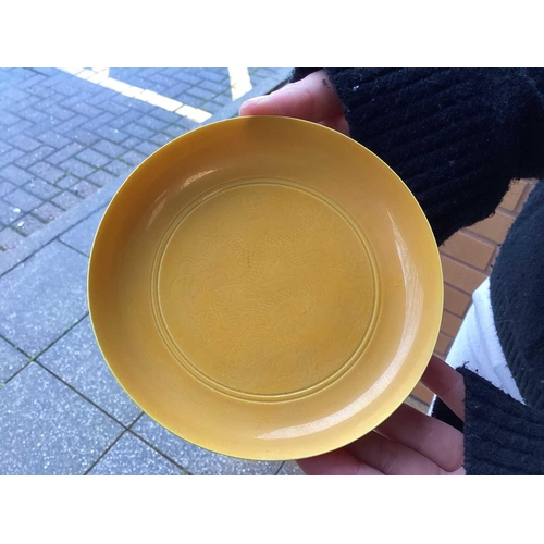 102 - A pair of Chinese yellow glazed Chinese porcelain saucers, bearing a six-character mark for Guangxu ... 