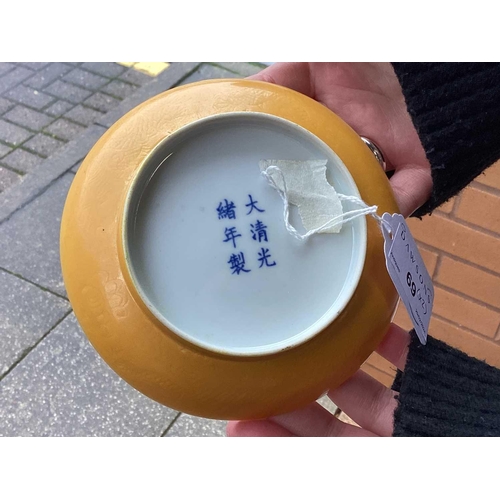 102 - A pair of Chinese yellow glazed Chinese porcelain saucers, bearing a six-character mark for Guangxu ... 