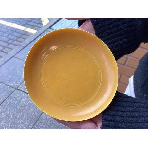 102 - A pair of Chinese yellow glazed Chinese porcelain saucers, bearing a six-character mark for Guangxu ... 