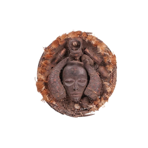 115 - A Chokwe Divination tray or dish, the well with a mask flanked by two horns, feather decoration to t... 