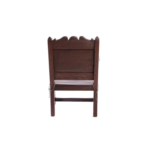 119 - An oak wainscot armchair, 17th century and later, with carved decoration, the arms terminating in ca... 