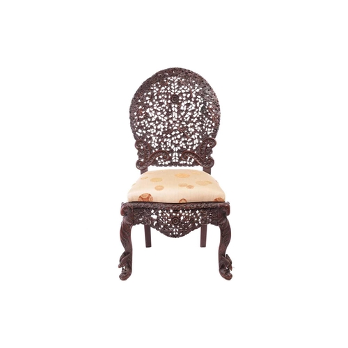 134 - An Indian 'Bombay Carved' padauk slipper chair 19th century, the arched back pierced and carved with... 