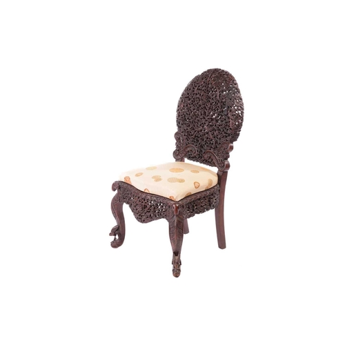 134 - An Indian 'Bombay Carved' padauk slipper chair 19th century, the arched back pierced and carved with... 