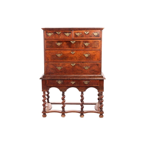 136 - A 17th-century and later figured walnut chest on stand, the upper section with quarter veneered top ... 