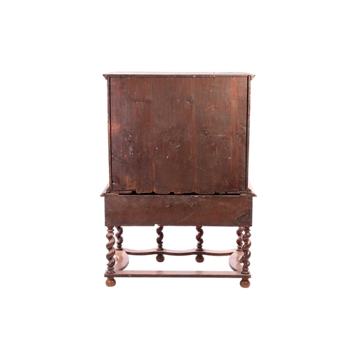 136 - A 17th-century and later figured walnut chest on stand, the upper section with quarter veneered top ... 