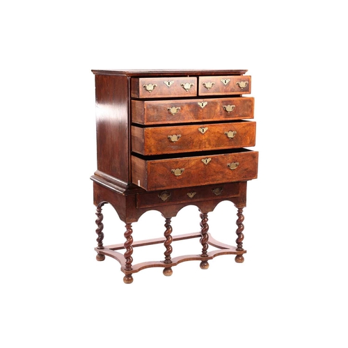 136 - A 17th-century and later figured walnut chest on stand, the upper section with quarter veneered top ... 