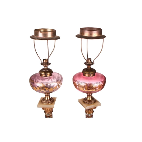 138 - A pair of 19th-century French onyx, gilt metal and champléve enamel oil lamp bases of Corinthian col... 