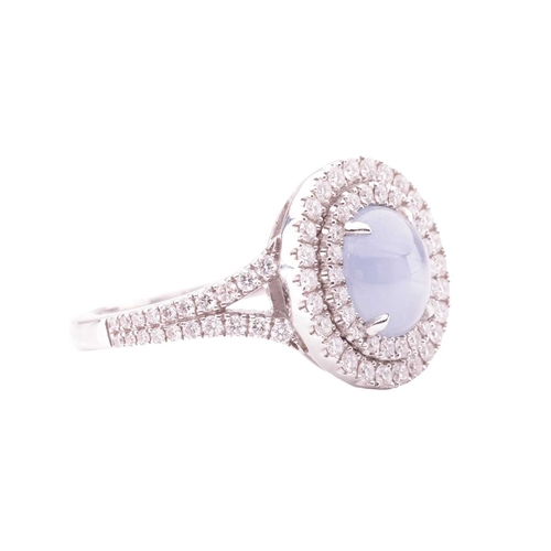 100 - A star sapphire and diamond cluster ring in 18ct white gold, centred with an oval star sapphire cabo... 