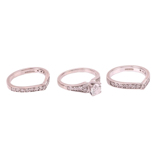 111 - A diamond solitaire ring and two diamond-set half-hoop eternity rings; the diamond solitaire ring se... 