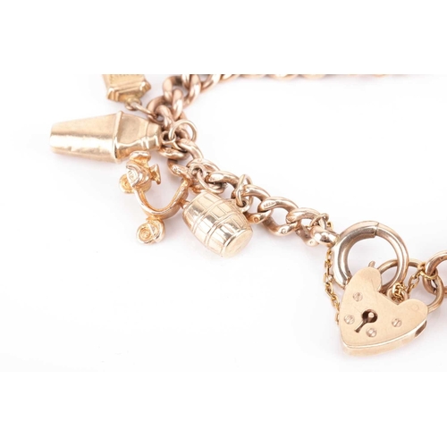 129 - A charm bracelet in 9ct gold, composed of a series of cable links, suspending with nineteen charms, ... 