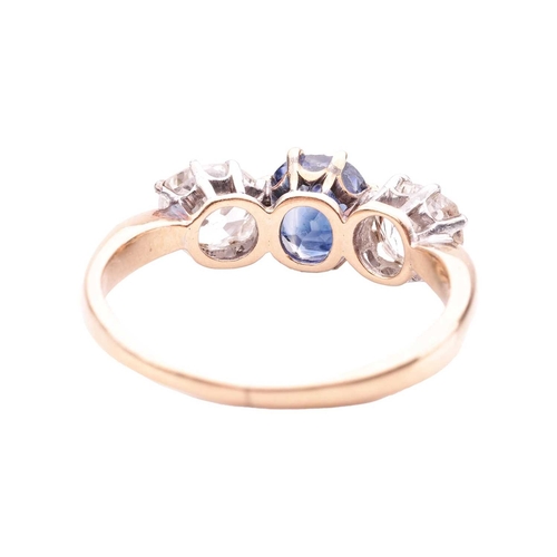 141 - A sapphire and diamond trilogy ring, centred with a cushion-shaped sapphire of intense blue colour, ... 