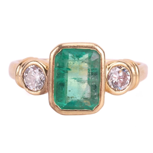 19 - An emerald and diamond three stone ring, set with an emerald measuring 8 x 6 x 3.6mm, flanked by rou... 