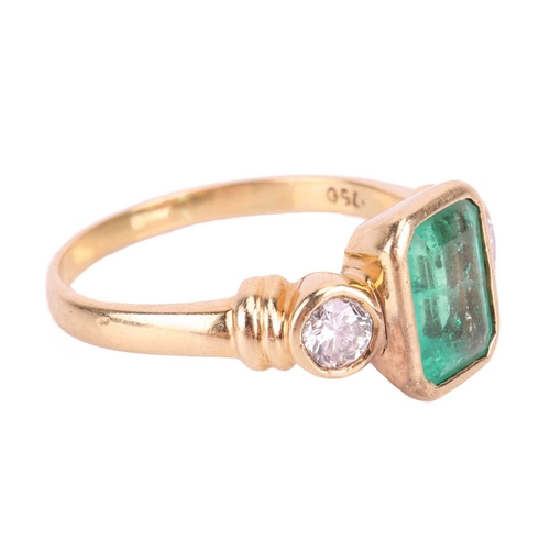 19 - An emerald and diamond three stone ring, set with an emerald measuring 8 x 6 x 3.6mm, flanked by rou... 