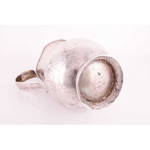 208 - A white metal jug possibly Bolivian of baluster form with a tapered loop handle and flared foot, 23 ... 