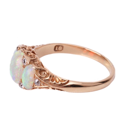 25 - An opal and diamond half-hoop ring, featuring three graduated oval cabochons, displaying spectral pl... 