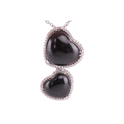 32 - A Whitby jet and diamond double heart pendant on chain, featuring two heart-shaped jet cabochons, fr... 