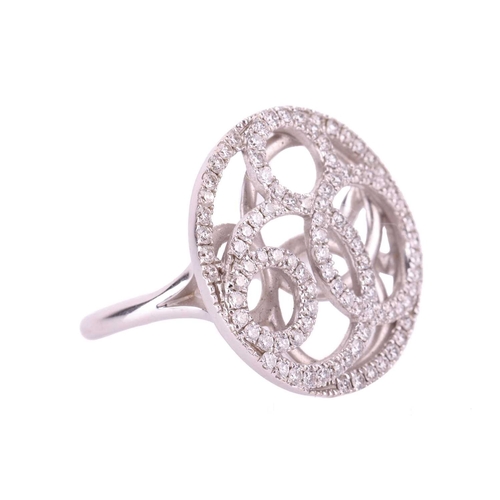 39 - A De Beers pierced panel ring in 18ct white gold, round head of swirl design encrusted with brillian... 