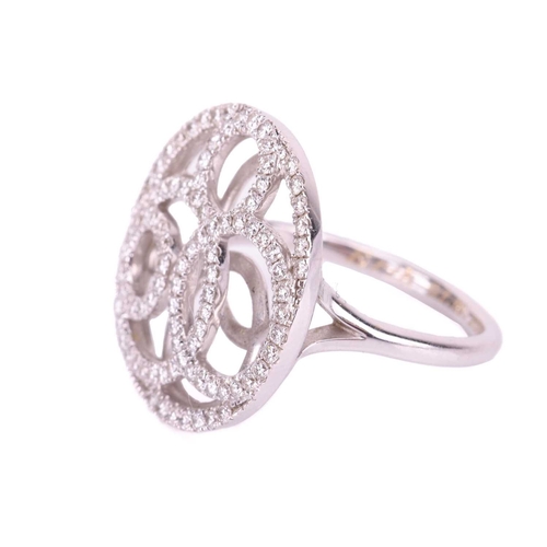 39 - A De Beers pierced panel ring in 18ct white gold, round head of swirl design encrusted with brillian... 