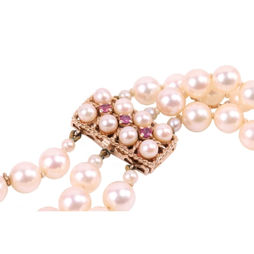 42 - A three-strand pearl choker necklace and matching bracelet, the cultured pearls of cream body colour... 