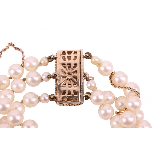 42 - A three-strand pearl choker necklace and matching bracelet, the cultured pearls of cream body colour... 