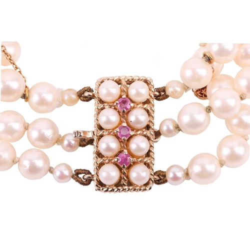 42 - A three-strand pearl choker necklace and matching bracelet, the cultured pearls of cream body colour... 