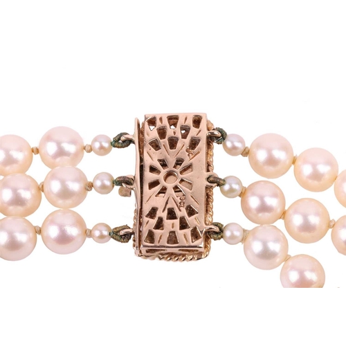 42 - A three-strand pearl choker necklace and matching bracelet, the cultured pearls of cream body colour... 