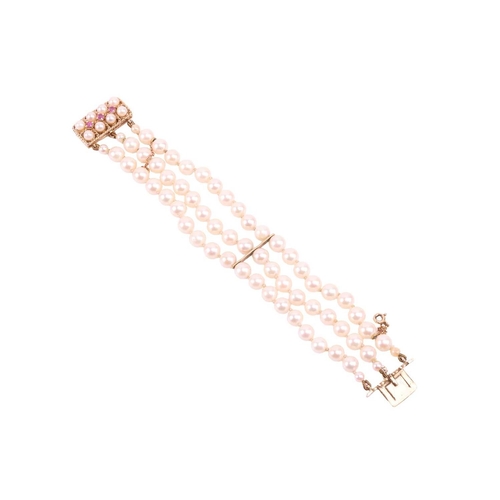 42 - A three-strand pearl choker necklace and matching bracelet, the cultured pearls of cream body colour... 