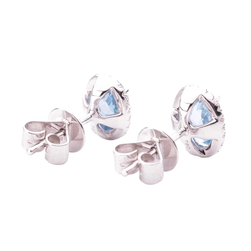 72 - A pair of aquamarine and diamond cluster stud earrings, each containing an oval-cut aquamarine of br... 