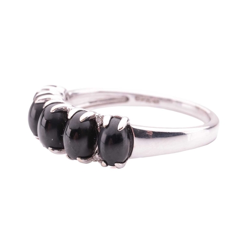 81 - A Whitby jet five-stone dress ring in 18ct white gold, claw-set with five oval jet cabochons, inters... 