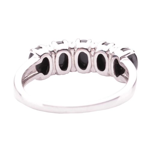 81 - A Whitby jet five-stone dress ring in 18ct white gold, claw-set with five oval jet cabochons, inters... 