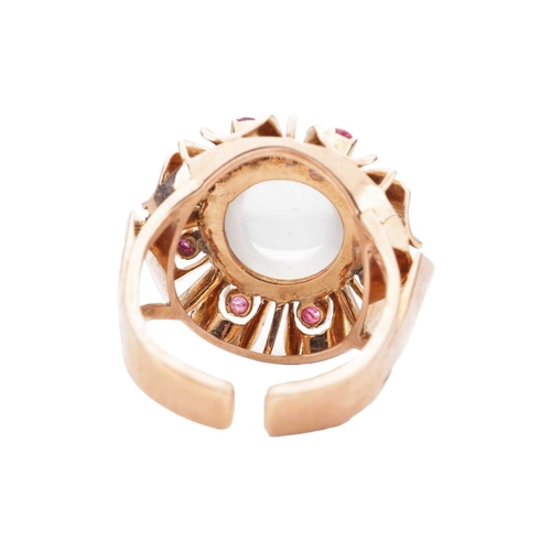 92 - A moonstone and ruby dress ring, centred with a round moonstone cabochon of 10.7 mm, in a surround e... 