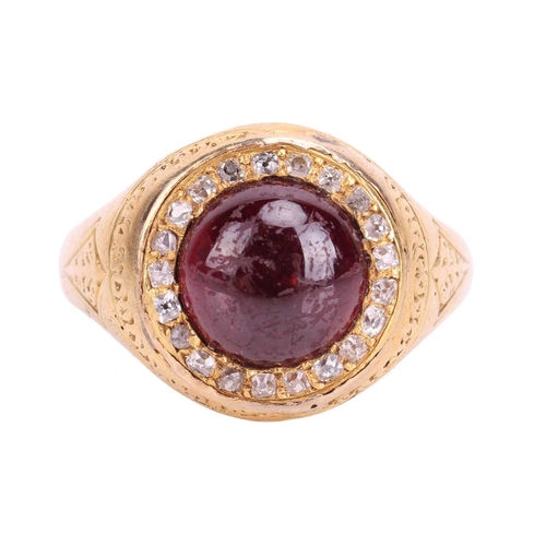 135 - A Victorian garnet and diamond halo ring in 18ct yellow gold, centred with a round garnet cabochon e... 
