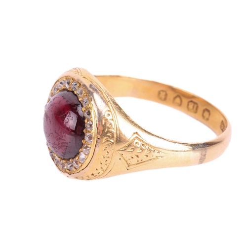 135 - A Victorian garnet and diamond halo ring in 18ct yellow gold, centred with a round garnet cabochon e... 