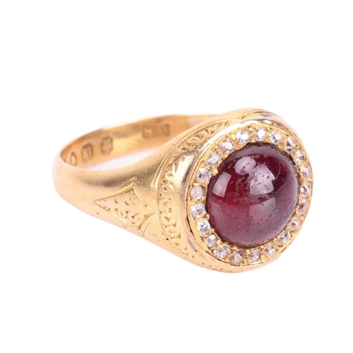 135 - A Victorian garnet and diamond halo ring in 18ct yellow gold, centred with a round garnet cabochon e... 