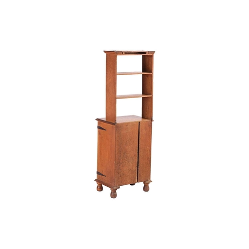 236 - An early 20th-century Cotswold School oak cupboard bookcase with open shelves and solid panel doors ... 