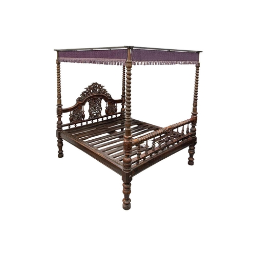 109 - A massive probably Ceylonese Four Poster Bed retailed by Liberty of London, with carved and pierced ... 