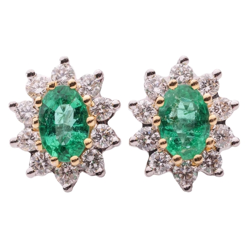 11 - A pair of emerald and diamond cluster earrings, the central oval-cut emeralds measuring approximatel... 