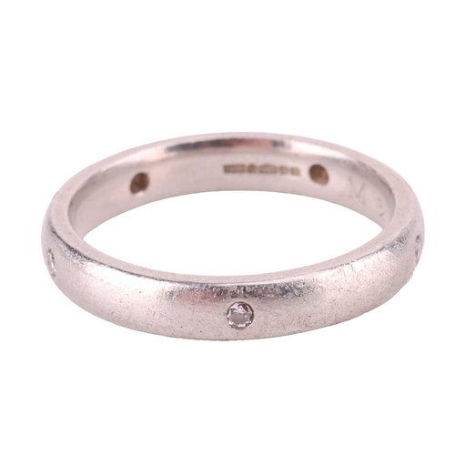 112 - A diamond-set wedding band in platinum, the court-shaped band flush-set with five brilliant-cut diam... 