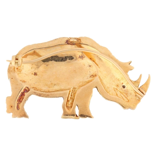 116 - A rhinoceros brooch in 18ct yellow gold, realistically modelled and textured, eye highlighted with a... 