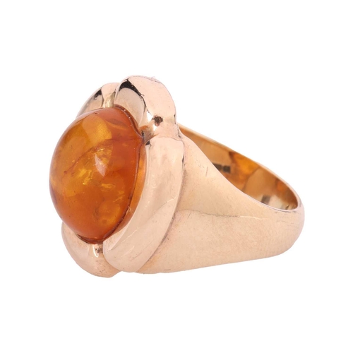 117 - An amber cabochon dress ring, centred with a circular amber cabochon of 11.8 x 5.2 mm, within a styl... 