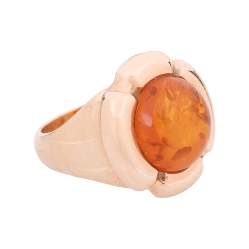 117 - An amber cabochon dress ring, centred with a circular amber cabochon of 11.8 x 5.2 mm, within a styl... 