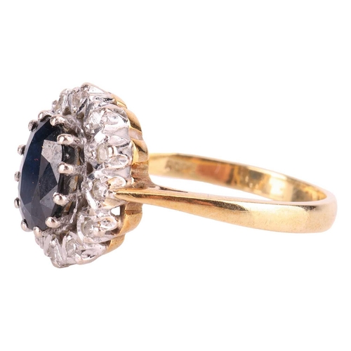 122 - A sapphire and diamond cluster ring in 18ct gold, comprising an oval-cut sapphire of dark blue colou... 