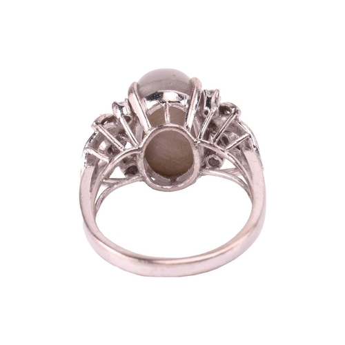 28 - A grey star sapphire and diamond dress ring, featuring an oval cabochon of a light grey sapphire cab... 