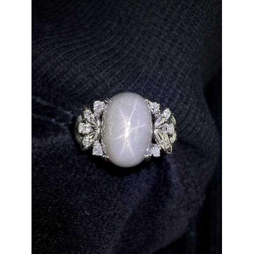 28 - A grey star sapphire and diamond dress ring, featuring an oval cabochon of a light grey sapphire cab... 