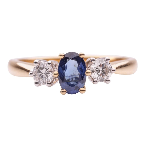 39 - A sapphire and diamond trilogy ring in 18ct yellow gold, centred with an oval-cut sapphire of 6.1 x ... 